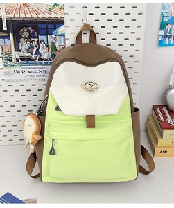 Detailed view of color-block student backpack with toast charm on pegboard display