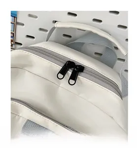 Close-up of smooth dual metal zippers and gray nylon handle on minimalist backpack
