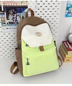 Detail of multi-color nylon school backpack featuring green, white, and brown panels