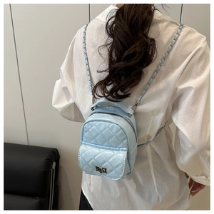 Detail of light blue quilted mini backpack with chain strap and silver twist lock