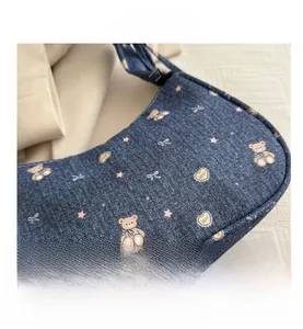 Détail d'un sac à bandoulière en jean bleu avec motifs d'ours et de cœurs