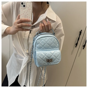 Detail eines hellblauen gesteppten Mini-Rucksacks mit silbernem Drehverschluss und Kette