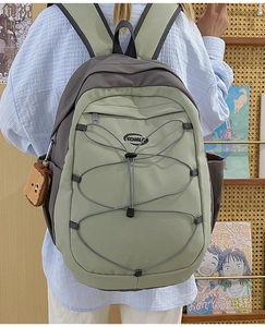 Détail du sac à dos en nylon bicolore avec cordons élastiques et pendentif en peluche