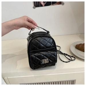 Detail eines gesteppten schwarzen Rucksacks mit silbernem Drehverschluss und Kette
