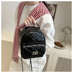 Detail eines schwarzen gesteppten Mini-Rucksacks mit Drehverschluss und Ketten