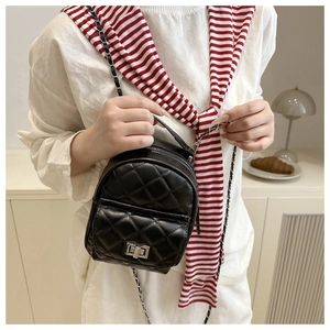 Detail eines schwarzen gesteppten Mini-Rucksacks mit silbernem Drehverschluss und Kette