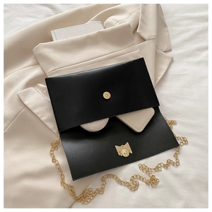 Interior view of black envelope chain bag showing storage for makeup and wallet