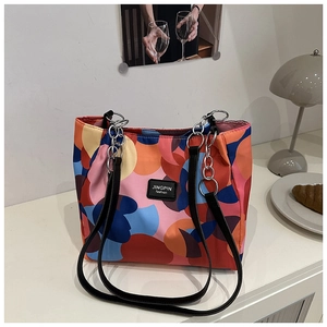 Nylon tote bag detail with colorful abstract art print and metal chain leather strap