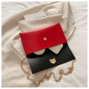 Interior detail of red and black envelope bag with gold chain and magnetic closure