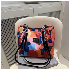 Close-up of waterproof tote bag with colorful abstract patterns and silver chain detail