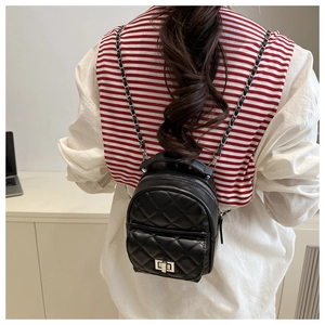 Detail eines schwarzen gesteppten Mini-Rucksacks mit Silberketten und Metalldrehverschluss