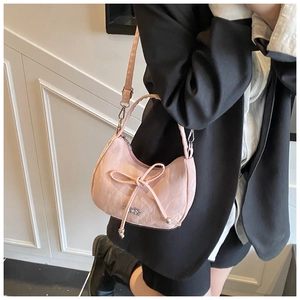 Détail du sac hobo rose clair avec cordon nœud et logo en métal argenté sur mannequin