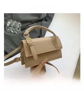 Detail view of khaki PU leather bag with gold buckle and adjustable shoulder strap