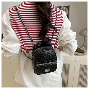 Schwarzer gesteppter Mini-Rucksack mit Kettenriemen und Drehverschluss am Model
