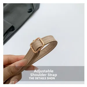 Detail of beige PU leather shoulder strap with adjustable light gold metal buckle