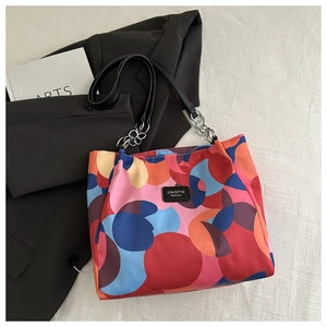 Detail of colorful geometric circle print and leather chain strap on tote bag