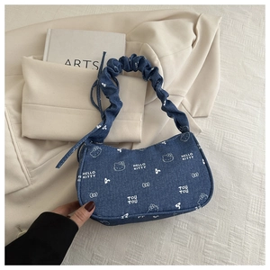Gros plan détaillé du sac en jean bleu avec des imprimés blancs Hello Kitty et motifs