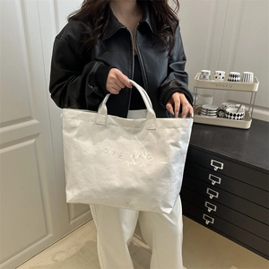 Sac fourre-tout blanc minimaliste avec texte embossé et texture industrielle