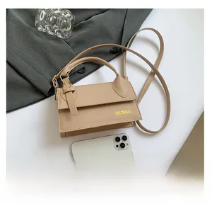 Detail view of khaki crossbody bag with smartphone for size reference and smooth texture