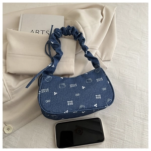 Détail du sac à épaule en jean bleu avec imprimé Hello Kitty et poignée froncée