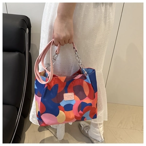 Close-up of waterproof Oxford tote bag with colorful geometric patterns and chain handles