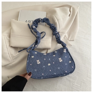 Détail du sac en jean bleu avec motifs d'ours et de nœuds et bandoulière de style chouchou