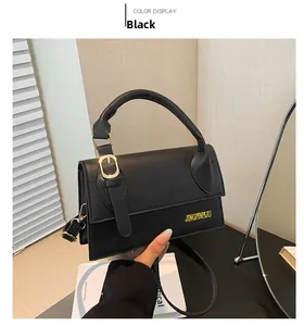 Detail shot of the black leather handbag featuring a vintage gold buckle and top handle