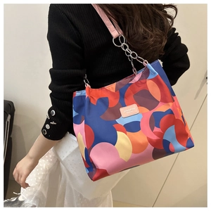 Macro shot of abstract colorful tote bag showing durable nylon fabric and leather brand tag