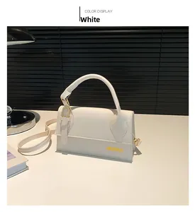 Detailed view of a white vintage square crossbody bag with gold logo on black background