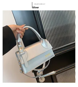 Detailed view of silver square bag featuring textured leather and a stylish buckle handle