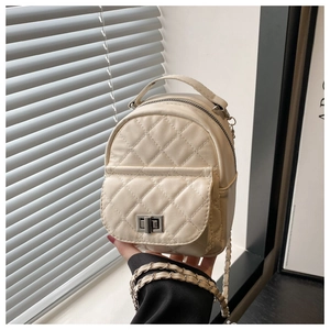 Detail eines gesteppten Mini-Rucksacks in Cremeweiß mit silbernem Drehverschluss und Kettenriemen