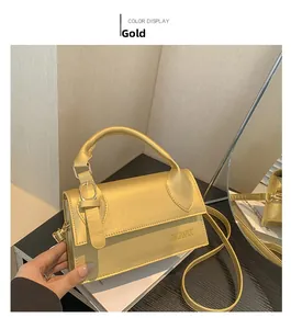 Detail view of the golden square crossbody bag with textured matte finish and flap cover