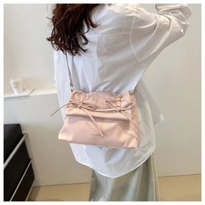 Detail of light pink soft PU leather bag with accordion pleats and double bow decor