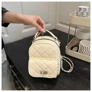 Detailaufnahme des cremefarbenen gesteppten Mini-Rucksacks mit silbernem Drehverschluss