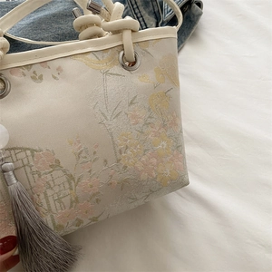 Embroidered bucket bag with floral jacquard pattern and silk tassel detailing