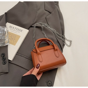 Mini sac cabas marron caramel minimaliste avec bandoulière chaîne argentée sur blazer