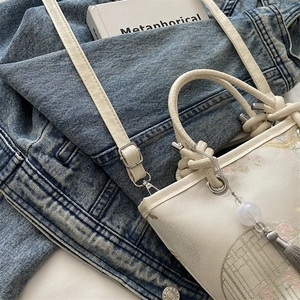 Oriental embroidered bucket bag in beige fabric with floral patterns and pearl tassel charm