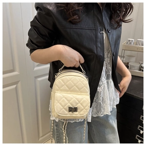 Detailansicht beige gesteppter Mini Rucksack mit silberner Kette und Drehverschluss