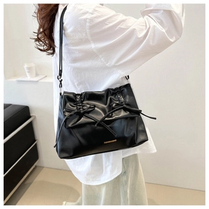 Side view of black bow-knot shoulder bag showing large capacity and drawstring details