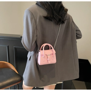 Vue détaillée d'un mini sac rose à bandoulière avec chaîne argentée et boucle