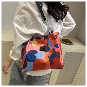 Detail of the colorful geometric pattern and silver chain strap on the waterproof shoulder bag
