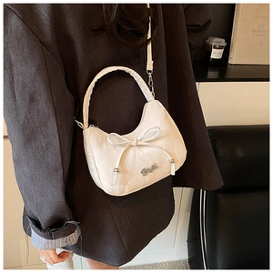 Détail du sac bandoulière en cuir plissé blanc avec nœud et logo métallique chic