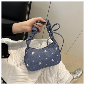 Détail du sac à main en denim floral avec poignée froncée rose et fermeture éclair