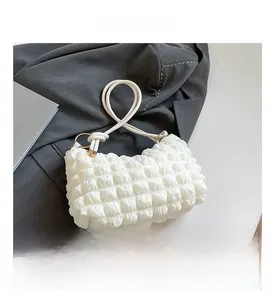 Detailed view of white bubble texture fabric and woven shoulder strap with metal ring