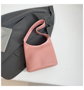 Detail of pink croc-embossed texture on a crescent shoulder bag with a matte finish