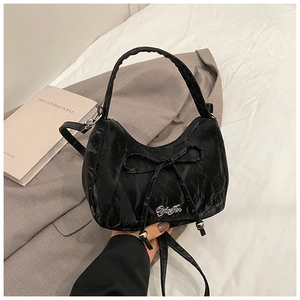 Detail of black bow shoulder bag with pleated texture and silver metallic logo detail