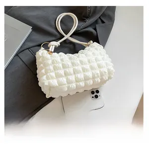 Close-up of white pleated tote bag with waffle texture and smartphone for size reference