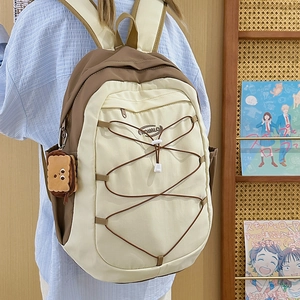 Sac à dos d'école minimaliste avec pendentif biscuit dans un cadre de campus douillet