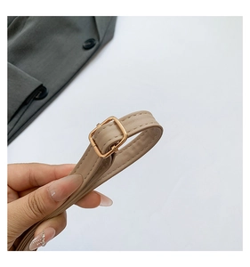 Detail of beige leather strap with gold square buckle and precise stitching