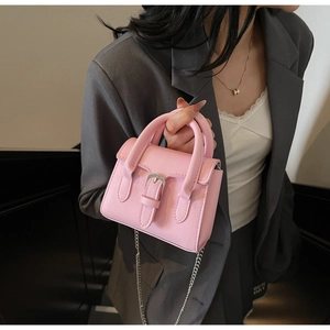 Mannequin portant un mini sac bandoulière rose avec boucle et chaîne sur un blazer gris